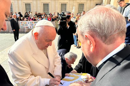 El papa Francisco firma la camiseta conmemorativa del Centenario de la Cultural en presencia del sacerdote de León José Manuel del Río. DL