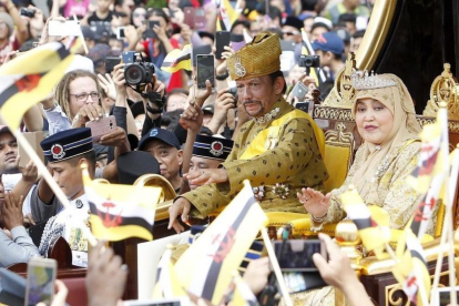El sultan Hassanal Bolkiah saluda a sus ciudadanos acompanado por su primera esposa, Pengiran Anak Saleha