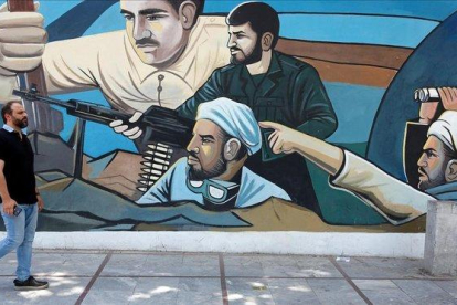 Un hombre camina delante de un mural en Teherán (Irán).