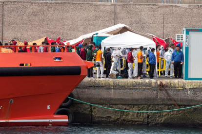 Decenas de personas llegadas en cayucos ayer, en el puerto de Arguineguín, en Gran Canaria. QUIQUE CURBELO