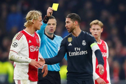 Sergio Ramos (d) recibe la amarilla durante el partido contra el Ajax.