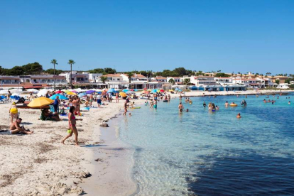 Decenas de personas disfrutaron ayer del sol en la playa de Punta Prima en Menorca. DAVID ARQUIMBAU SINTES