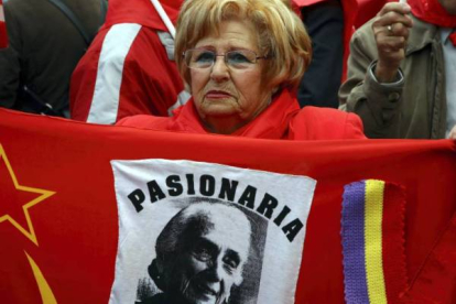 Una mujer muestra una imagen de la Pasionaria durante la concentración en la capital de España. Foto: AGUSTÍN CATALÁN