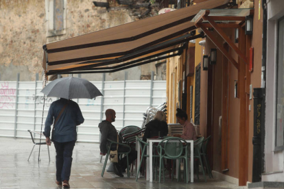 Una persona se protege de la lluvia con un paraguas. DL