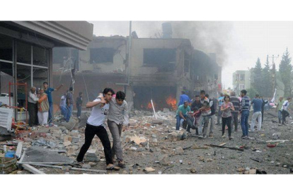 Ciudadanos turcos huyen del lugar de la explosión, este sábado en Reyhanli.