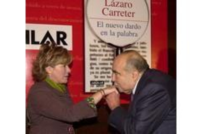 Lázaro Carreter besa la mano de la ministra antes de presentar su libro
