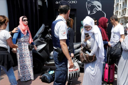 La policía francesa controla a unas mujeres antes del evento organizado en favor del burkini.