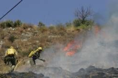 Dos trabajadores forestales apagan un incendio en la comarca, en una imagen de archivo