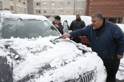 Vecinos de Armunia limpian su coche. RAMIRO