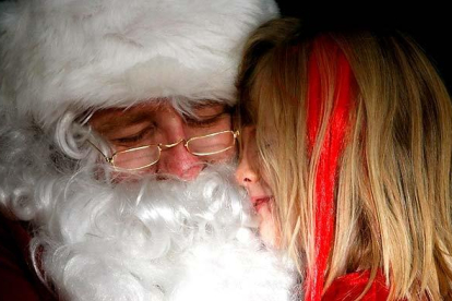 Sentrina Klostermann de cinco años abraza a Papa Noel en un centro comercial de Dubuque, Iowa (Estados Unidos).
