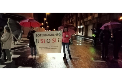 Manifestantes del soterramiento de Trobajo sosteniendo sus pancartas, este viernes. J. NOTARIO