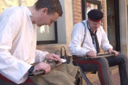 Dos figurantes ingleses limpian sus armas antes del ensayo de ayer