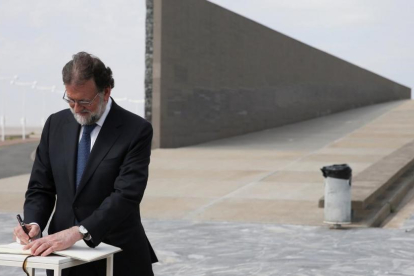 Rajoy en Argentina, firmando en el Parque de la Memoria