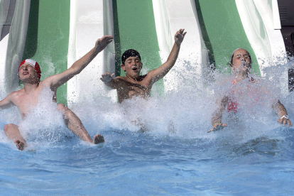 Mayores y niños disfrutan de los toboganes de la piscina de Valencia de Don Juan. BRUNO MORENO
