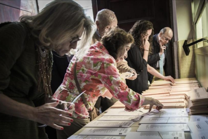 Un grupo de electores revisa papeletas en unas elecciones.