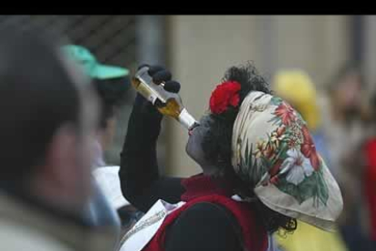 Uno de los participantes del desfile sacia su sed con un buen lingotazo de cerveza