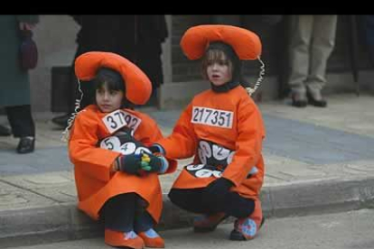 Unas niñas descansan del trajín que supone participar en el desfile carnavalesco