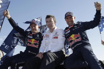 Stéphane Peterhansel, a la izquierda, junto al jefe de Peugeot, Bruno Famin, y su copiloto Jean Paul Cottret.