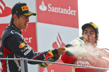 Vettel celebra en el podio junto a Fernando Alonso su triunfo en Monza que le deja a las puertas de revalidar el título de campeón.