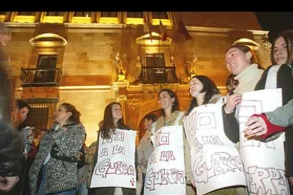 Chicos y chicas con grandes carteles prendidos de sus cuerpos reclaman la paz en el mundo.