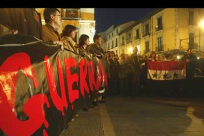 Las letras rojas de 'no a la guerra' destacan en la oscuridad de la noche.