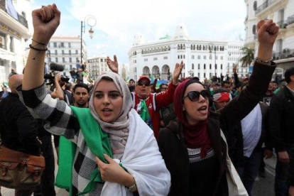 Ciudadanos argelinos gritan consignas y ondean banderas nacionales durante una protesta contra el presidente interino, Abdelkader Bensalah, en Argel.