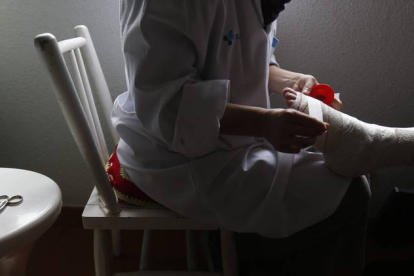 Una enfermera hace una cura a una paciente en Lillo del Bierzo