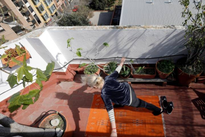 Una mujer practiacndo ejercicio en su terraza, en Valencia. JUAN CARLOS CÁRDENAS