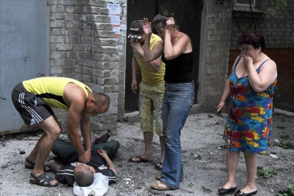 Un hombre intenta reanimar a un herido como consecuencia de los enfrentamientos entre los separatistas pro rusos y tropas ucranianas en Slavyansk ,Ucrania