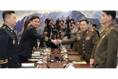 El general norcoreano An Ik San (derecha) da la mano a su homólogo surcoreano, Kim Do-gyun.