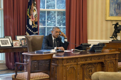 Barack Obama habla por teléfono en el despacho oval de la Casa Blanca.
