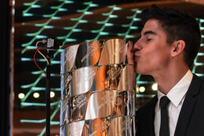 Marc Márquez besa el trofeo de plata maciza en el que están inscritos los nombres de todos los campeones de Moto GP.