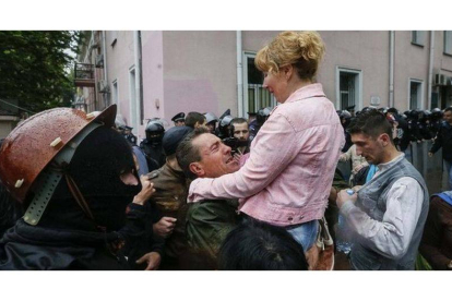 Un hombre y una mujer se abrazan tras la liberación de los arrestados de Odesa, este domingo.