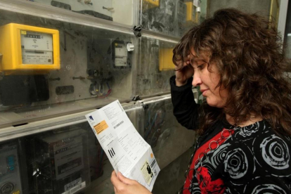 Una mujer comprueba la lectura del contador de electricidad.
