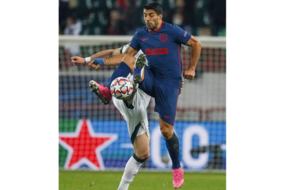 Luis Suárez intenta controlar el balón ante un rival. KOTECTKOV