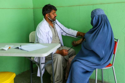 Un médico ausculta en Kabul a una mujer afgana con el burka puesto. STRINGER
