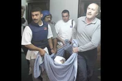 Los periodistas trasladan a uno de sus colegas heridos en el hotel en el que se hospedaban la mayoría de los informadores internacionales.