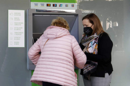 Imagen de dos mujeres ante un cajero automático de un banco. MARCIANO PÉREZ