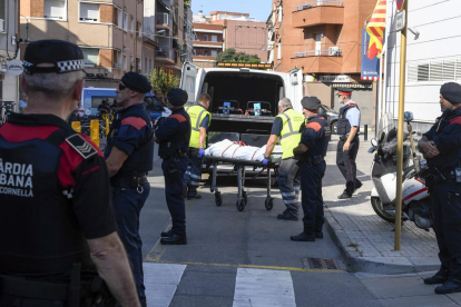 Miembros de la funeraria judicial retiran el cadáver del agresor de la comisaría de los Mossos en Cornellà