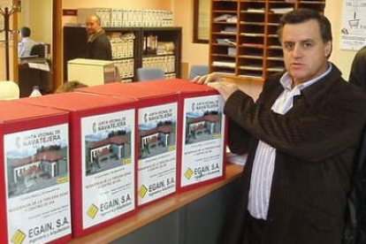 El alcalde muestra las cajas que contienen el proyecto, con el dibujo en el exterior de la futura re