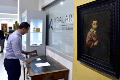 Un trabajador de la casa de subastas Abalarte manipula el óleo atribuido a Velázque 'Retrato de una niña'.