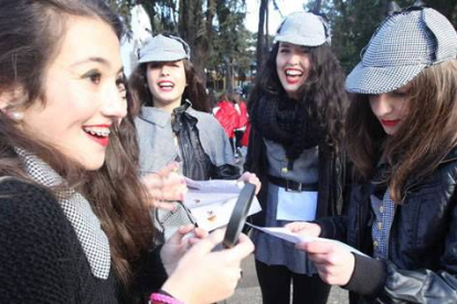 Un grupo de jóvenes disfrazadas de Sherlock Holmes, durante el juego del rompecabezas de Ponferrada, investigan con su lupa la lista de 33 pistas. L. de la Mata