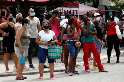 Varias personas esperan para comprar ayer en un mercado de La Habana. ERNESTO MASTRASCUSA
