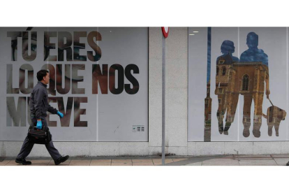 Un hombre paseando ayer ante un establecimiento cerrado en León.