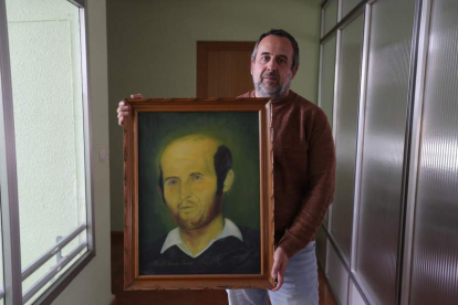 El secretario comarcal de CCOO, Ursicino Sánchez, en Fabero con el retrato de Joaquín Suárez. DE LA MATA