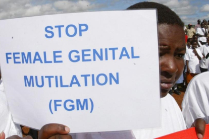 Una mujer sostiene una cartel contra la Mutilación Genital Femenina en una protesta en Kenia.