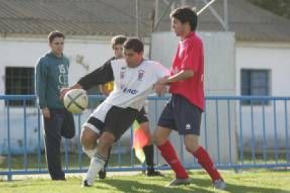 Quijada, a la izquierda, despeja un balón ante la oposición del jugador benaventano Pablo Carbajal