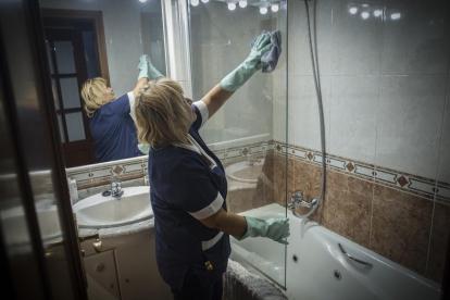 Una mujer de limpieza en un hogar realizando sus labores profesionales.  /