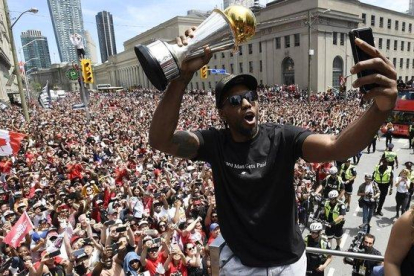 Kawhi Leonard se hace un selfie con el trofeo de campeón de la NBA.