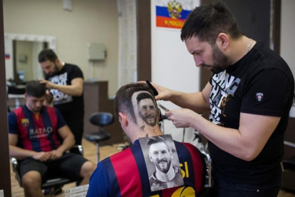 Mario Hvala, en plena tarea de esculpir el retrato de Messi en la cabeza de un seguidor del Barça de Novi Sad.
